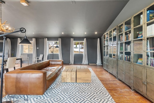 living room featuring vaulted ceiling, recessed lighting, and wood finished floors