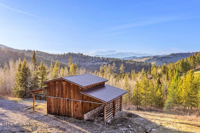 view of outdoor structure with a mountain view and a wooded view