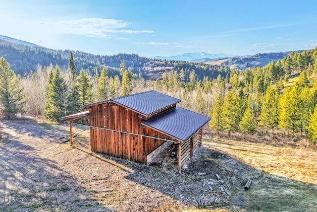 view of outbuilding with a view of trees and a mountain view