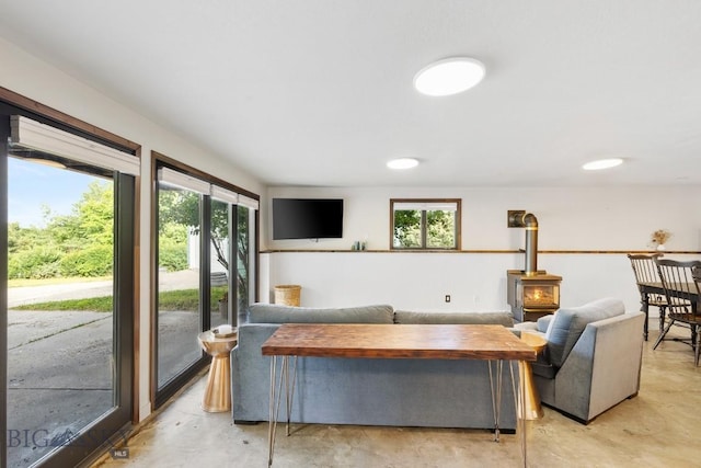 living room featuring concrete floors and a wood stove