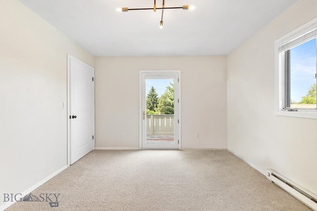 carpeted spare room with baseboards and a baseboard heating unit