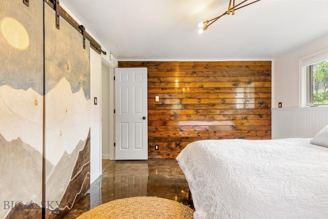 bedroom featuring wooden walls and a barn door
