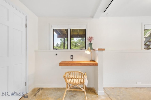 sitting room featuring baseboards, concrete floors, and a wealth of natural light
