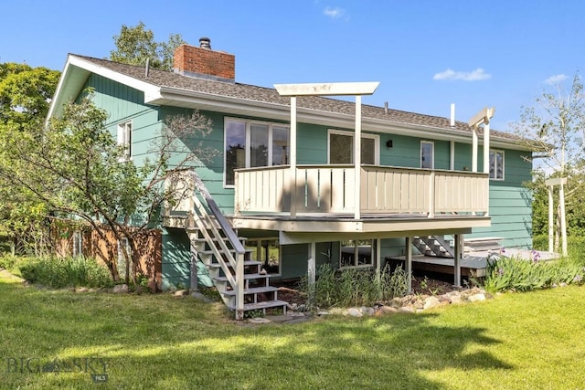 rear view of property featuring stairs, a lawn, a chimney, and a deck