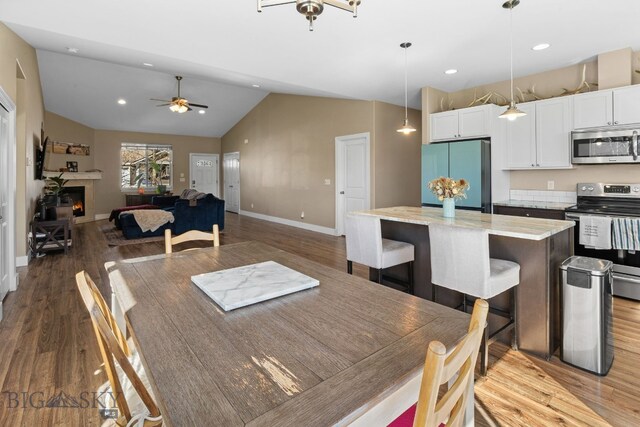 1604 Drummond Blvd, Belgrade, MT 59714 - dining room featuring baseboards, a ceiling fan, wood finished floors, and vaulted ceiling