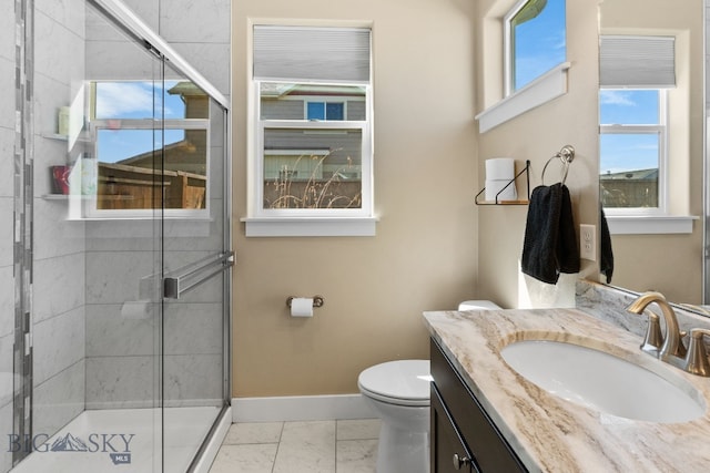 1604 Drummond Blvd, Belgrade, MT 59714 - bathroom featuring vanity, toilet, marble finish floor, baseboards, and a shower stall