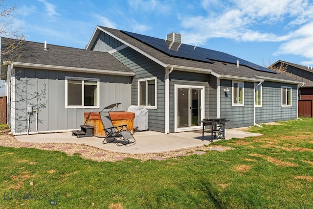 1604 Drummond Blvd, Belgrade, MT 59714 - back of property featuring board and batten siding, a lawn, solar panels, and a patio area