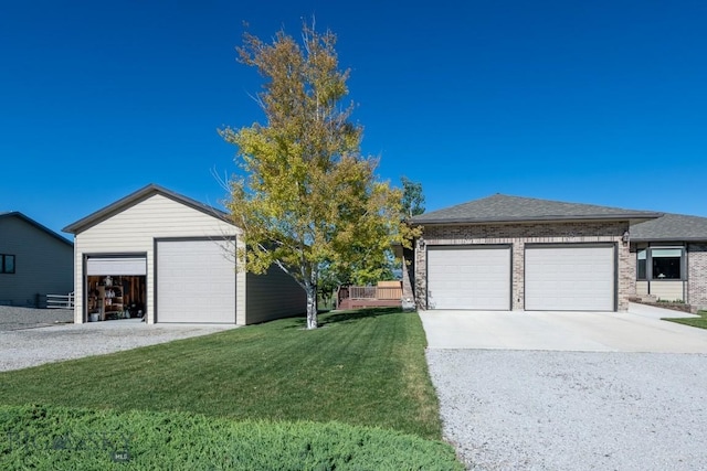 ranch-style house with brick siding, a front lawn, and a detached garage