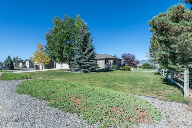 view of yard with fence and driveway