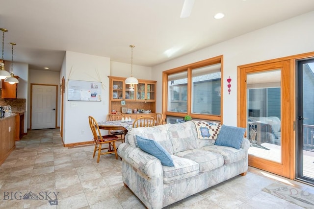 living room featuring recessed lighting, baseboards, and stone finish flooring