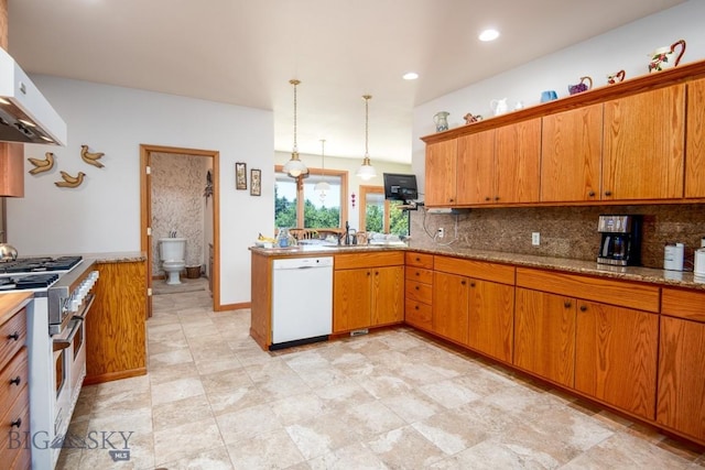 kitchen with brown cabinetry, a peninsula, tasteful backsplash, range with two ovens, and dishwasher