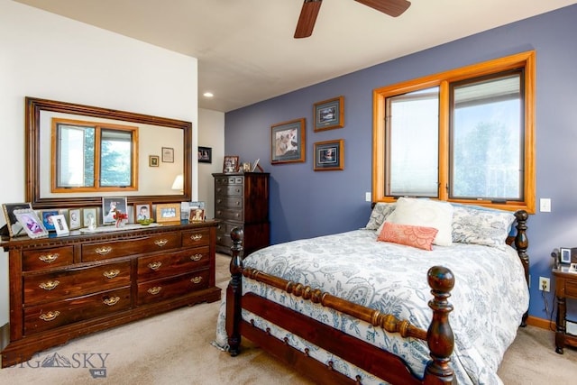 bedroom with a ceiling fan, baseboards, light carpet, and multiple windows