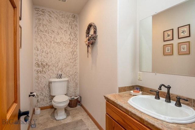 bathroom featuring vanity, baseboards, and toilet