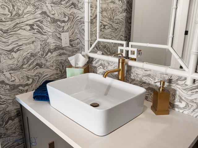 bathroom with a sink and wallpapered walls