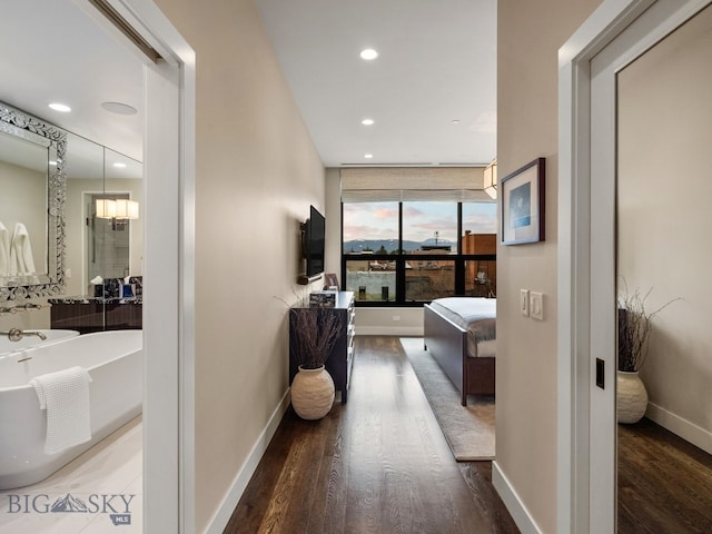 hall featuring recessed lighting, baseboards, and wood finished floors