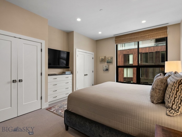 bedroom featuring recessed lighting, carpet flooring, and multiple closets