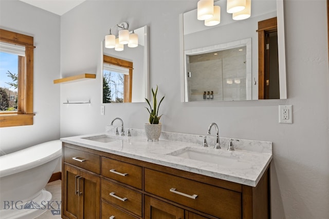 bathroom with a sink, a stall shower, and a healthy amount of sunlight
