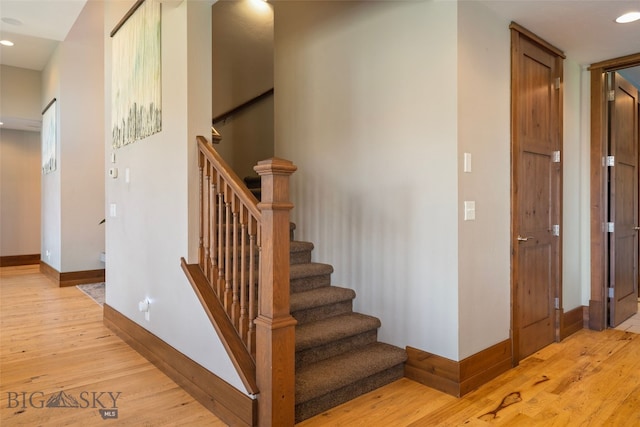 stairway with baseboards, recessed lighting, and wood finished floors