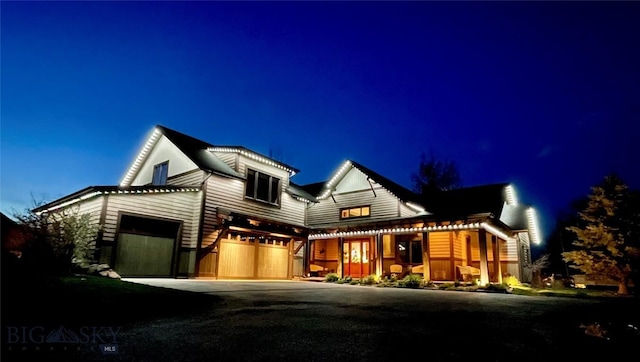 modern farmhouse style home featuring an attached garage and aphalt driveway