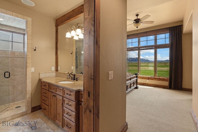 bathroom with vanity, a ceiling fan, a healthy amount of sunlight, and a stall shower