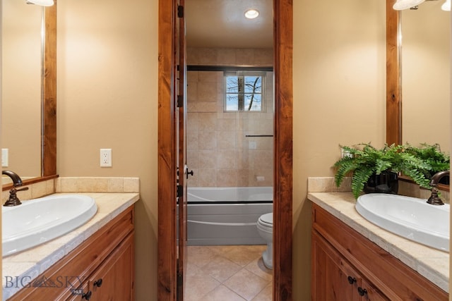 bathroom with a sink, shower / bath combination with glass door, and two vanities