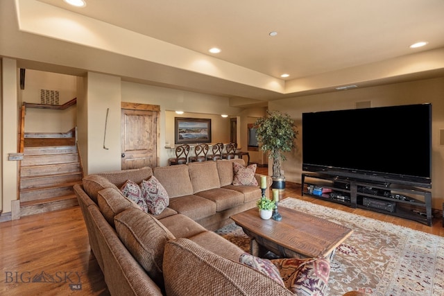 living area featuring visible vents, stairs, wood finished floors, a raised ceiling, and recessed lighting