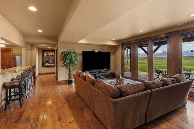living area with recessed lighting, visible vents, and wood finished floors