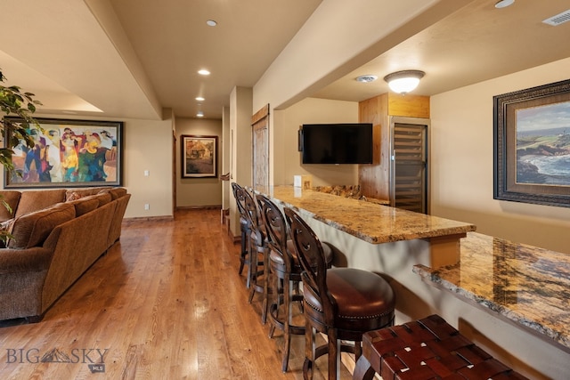 bar featuring visible vents, beverage cooler, indoor bar, recessed lighting, and light wood finished floors
