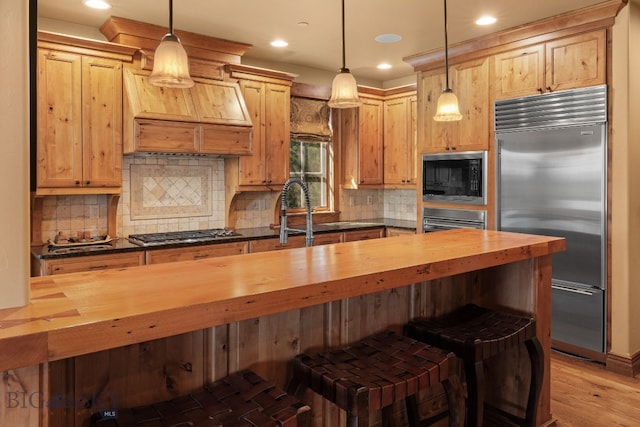 kitchen featuring light wood-style floors, wood counters, built in appliances, and tasteful backsplash