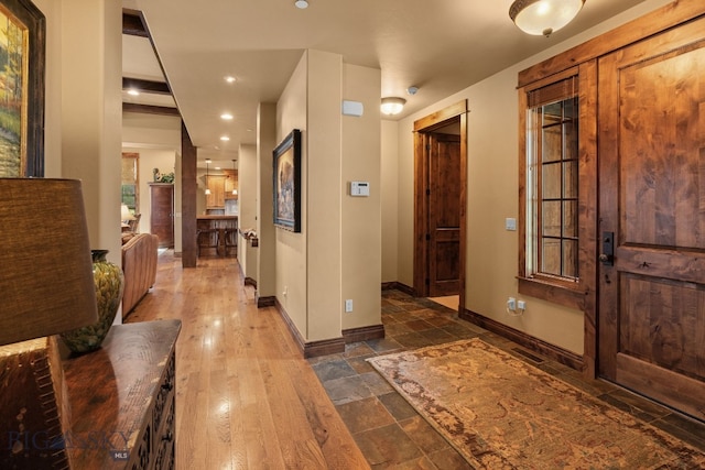entrance foyer featuring baseboards, stone tile floors, visible vents, and recessed lighting
