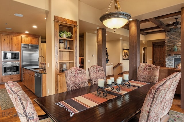dining area with ornate columns, recessed lighting, built in features, and wood finished floors