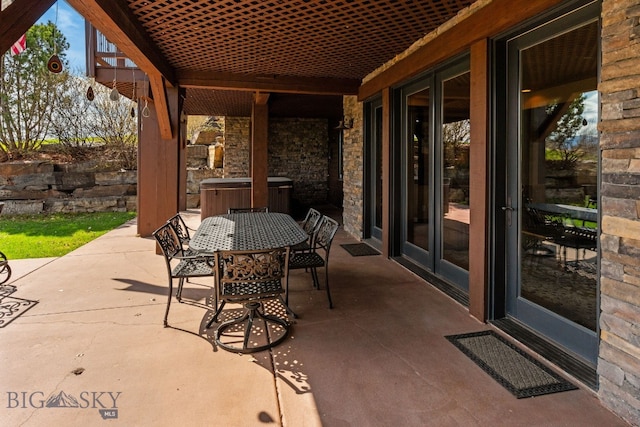 view of patio / terrace with outdoor dining area, a hot tub, and central air condition unit