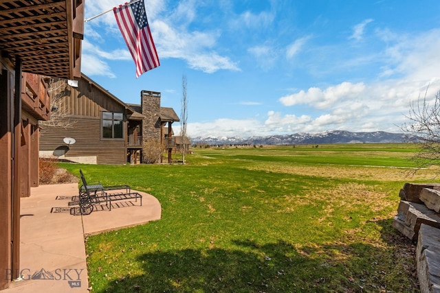 view of yard with a mountain view and a patio area