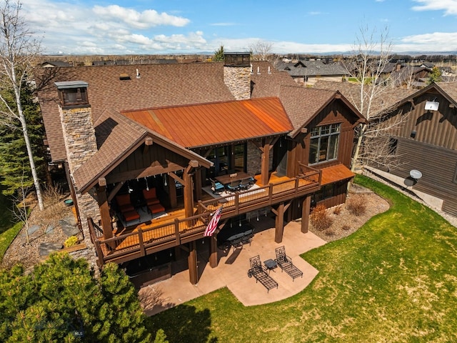 back of property featuring a lawn, a patio, a chimney, and a deck