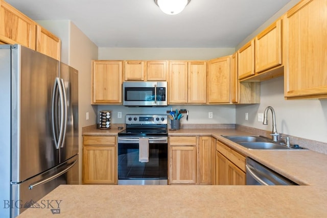 kitchen with a sink, light brown cabinets, and stainless steel appliances
