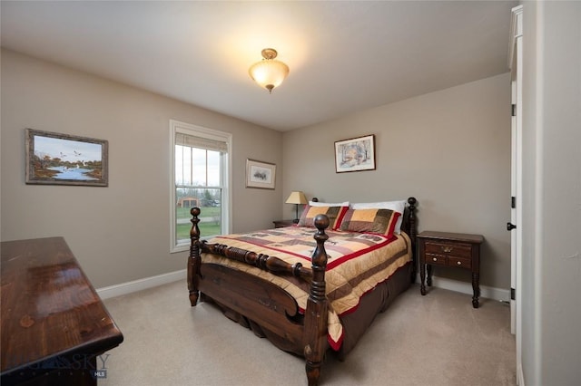 bedroom with baseboards and light colored carpet