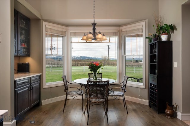 dining room with baseboards, dark wood-style flooring, and a notable chandelier