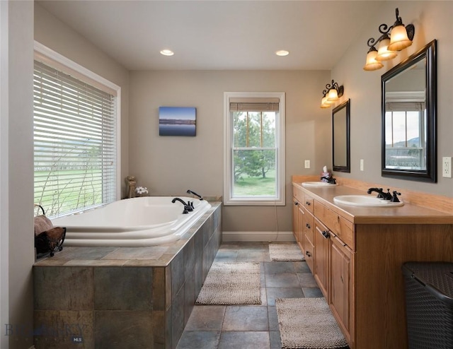 full bathroom featuring a sink, double vanity, a garden tub, and stone tile flooring