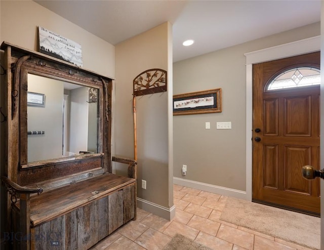 foyer entrance featuring light tile patterned floors and baseboards