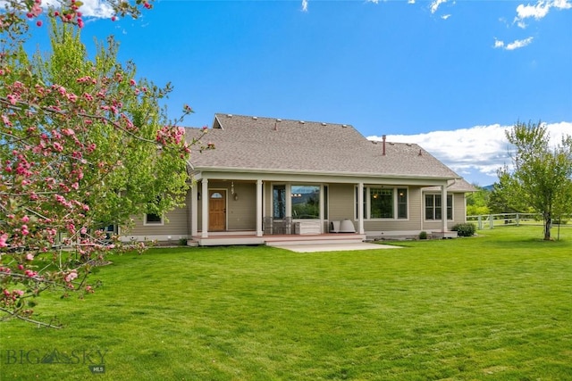 rear view of house with a yard, a patio, and fence