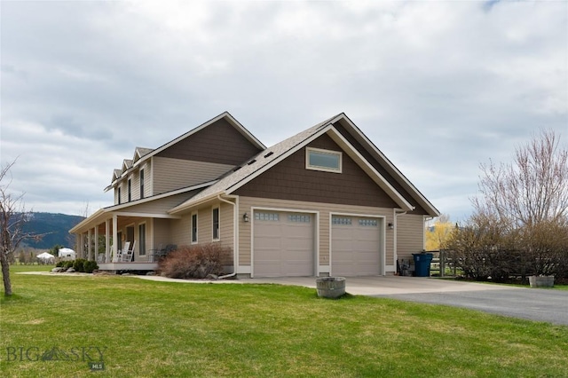 view of front of house featuring an attached garage, a front yard, concrete driveway, a porch, and a mountain view