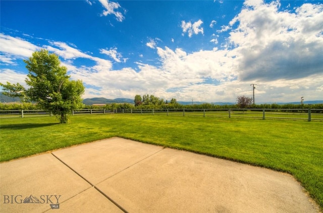 exterior space with a mountain view, fence, and a rural view