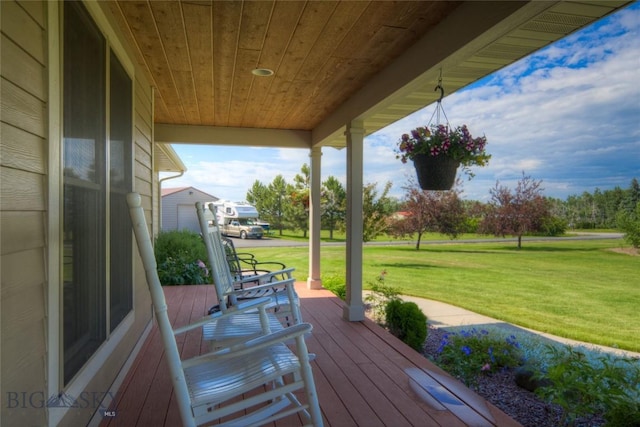 wooden deck featuring a lawn and covered porch