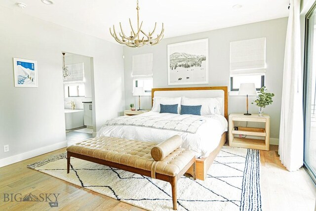 bedroom with baseboards, light wood-style floors, and a chandelier