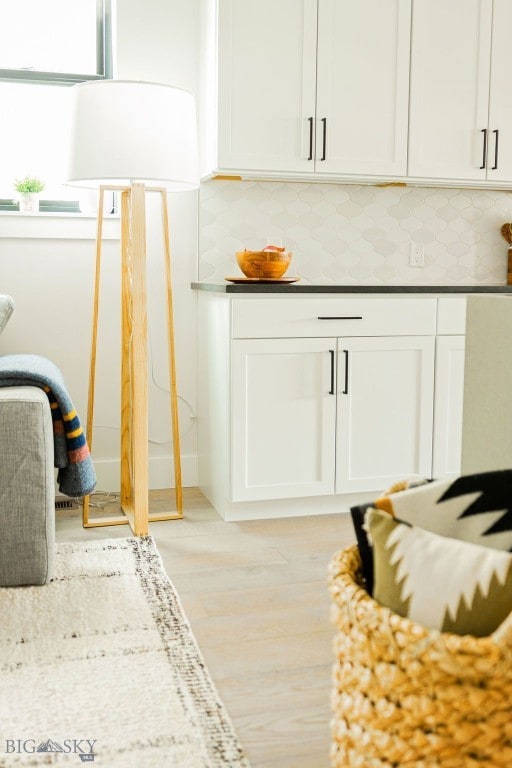 interior space with light wood-style flooring and backsplash