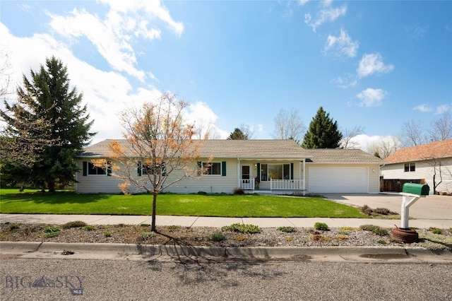 ranch-style home featuring covered porch, an attached garage, driveway, and a front yard