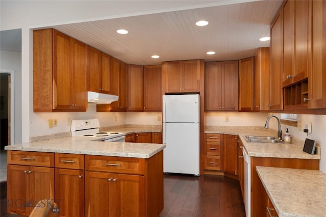 kitchen with white appliances, brown cabinets, dark wood-style floors, and a sink