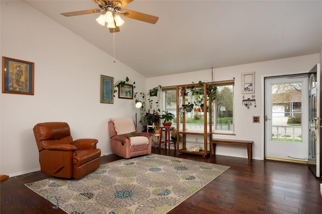 living area featuring wood-type flooring, a ceiling fan, baseboards, and a wealth of natural light