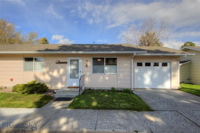 ranch-style house with a shingled roof, an attached garage, and concrete driveway