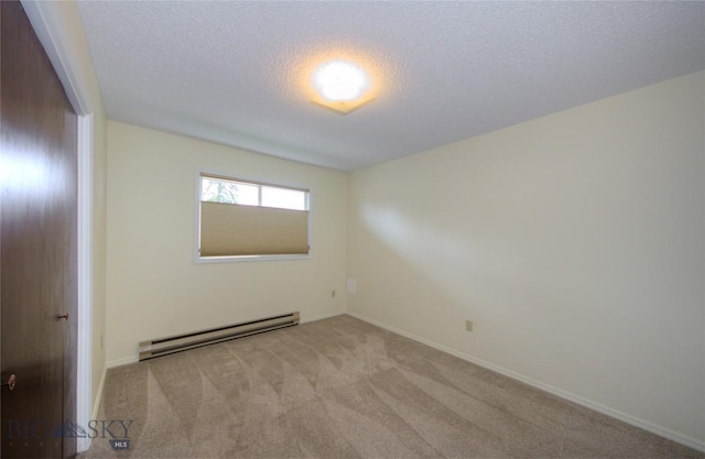 carpeted empty room featuring a textured ceiling, baseboards, and a baseboard radiator